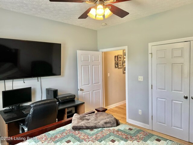 bedroom featuring a textured ceiling, wood-type flooring, and ceiling fan