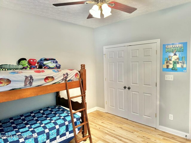 bedroom with a closet, a textured ceiling, hardwood / wood-style flooring, and ceiling fan