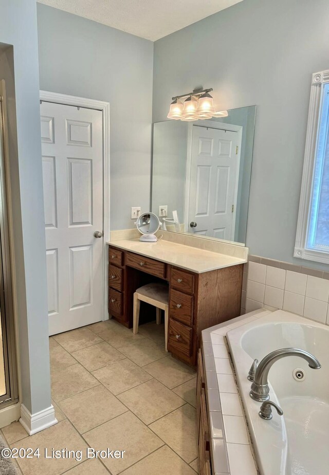 bathroom featuring vanity, tiled bath, and tile patterned flooring