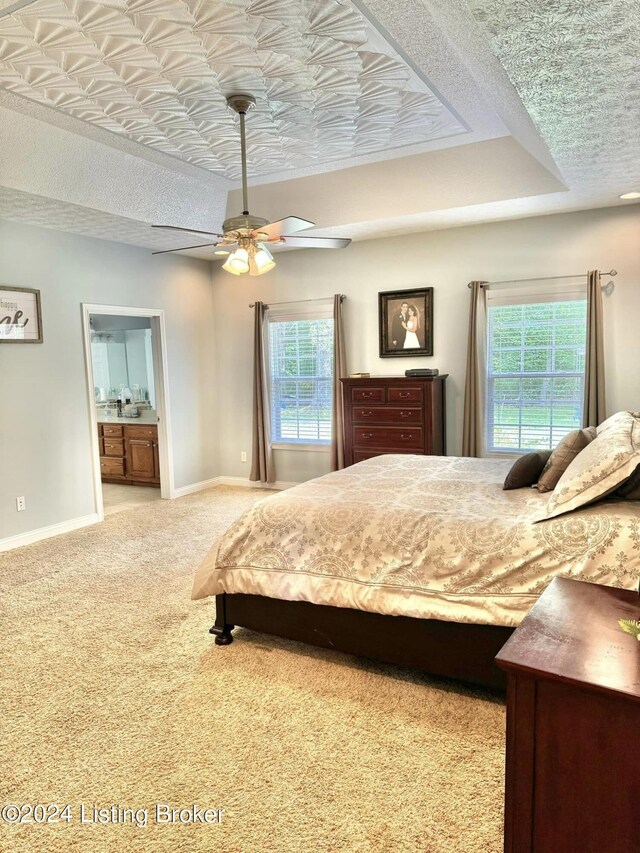 carpeted bedroom featuring a textured ceiling, ensuite bathroom, and ceiling fan