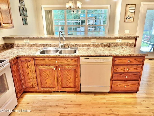 kitchen featuring hanging light fixtures, light wood-type flooring, a notable chandelier, sink, and white appliances