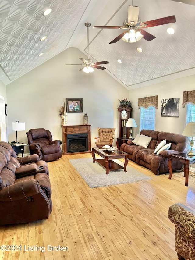 living room featuring high vaulted ceiling, light hardwood / wood-style floors, and ceiling fan