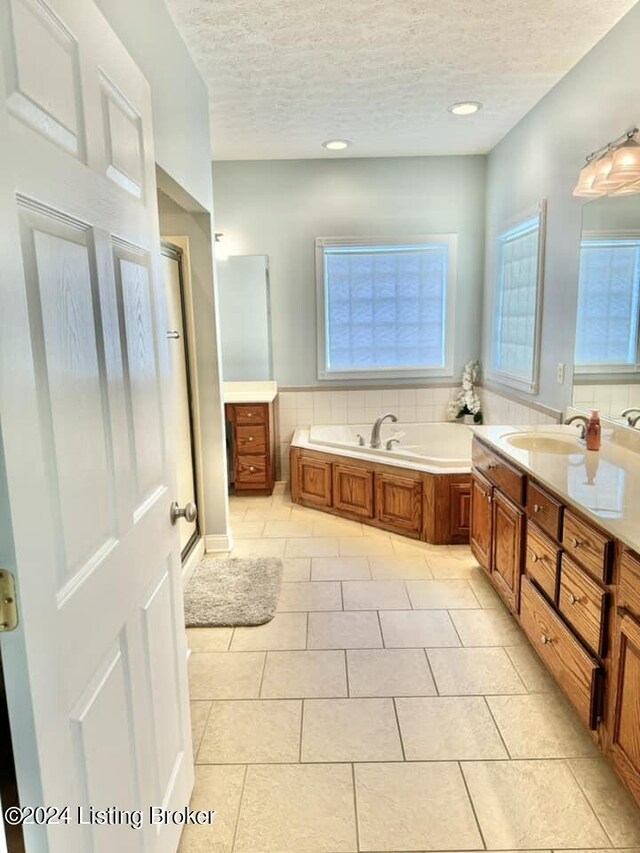 bathroom with vanity, tile patterned floors, a textured ceiling, and separate shower and tub