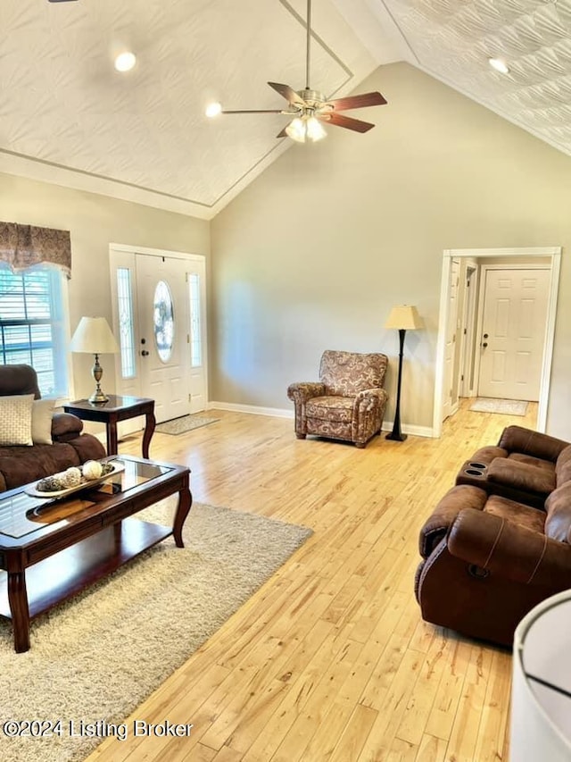 living room with ceiling fan, high vaulted ceiling, and light hardwood / wood-style flooring