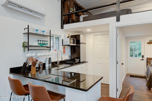 kitchen with a wall mounted AC, black electric cooktop, dark wood-type flooring, a sink, and white microwave