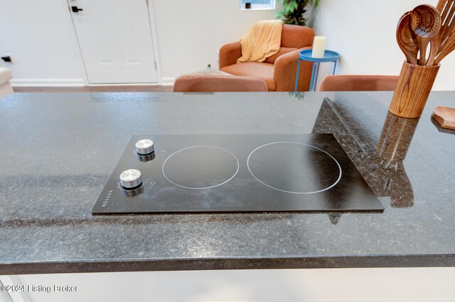 room details featuring black electric cooktop and white cabinets