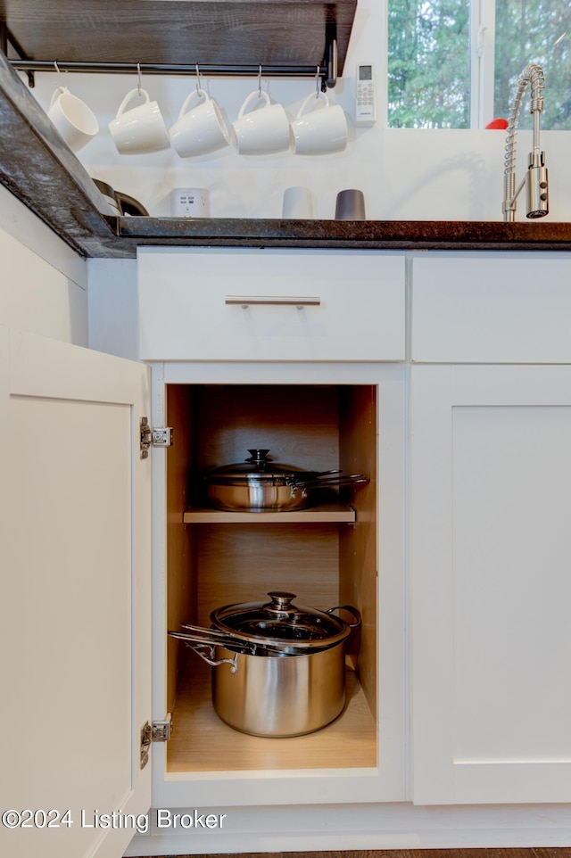 room details featuring white cabinetry and dark stone countertops