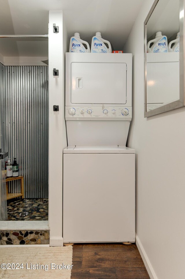 clothes washing area with stacked washer and dryer and dark wood-type flooring