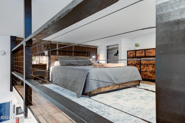 bedroom featuring wood finished floors and beam ceiling