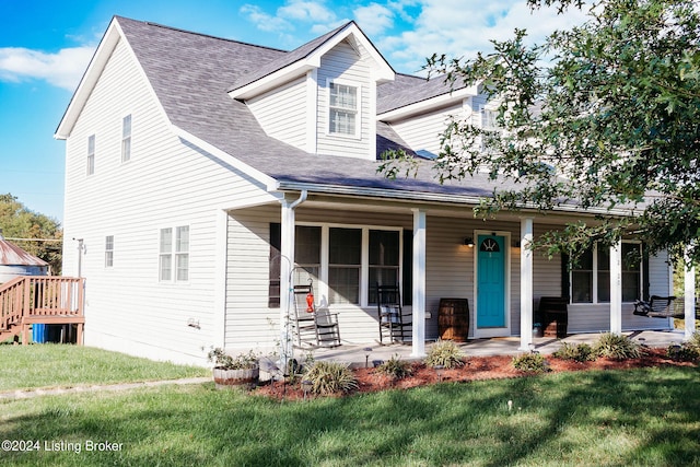 cape cod home featuring covered porch and a front yard