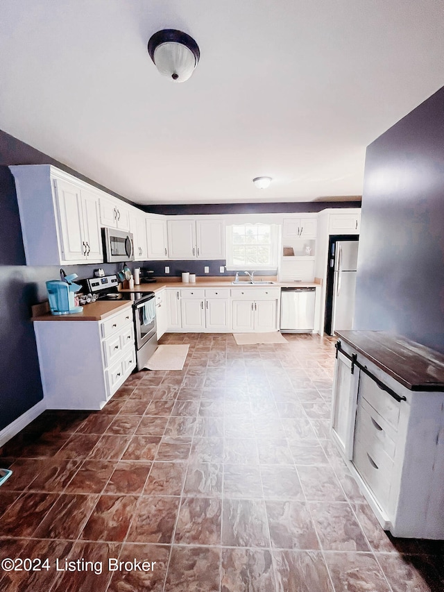 kitchen featuring white cabinets, appliances with stainless steel finishes, and sink