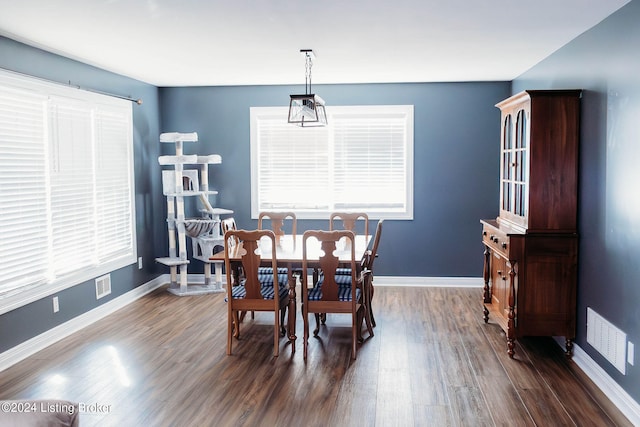 dining room with a notable chandelier and dark wood-type flooring