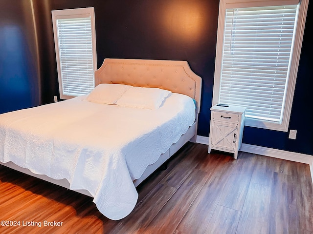 bedroom with dark hardwood / wood-style floors