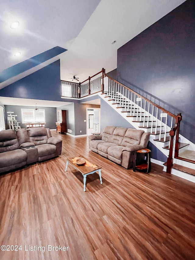 living room with hardwood / wood-style floors, ceiling fan, and high vaulted ceiling