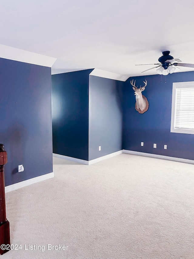 empty room featuring ceiling fan and light colored carpet