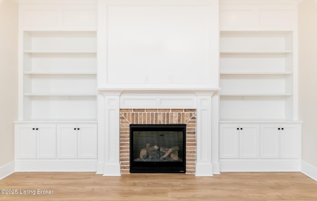 unfurnished living room with a brick fireplace and light hardwood / wood-style floors