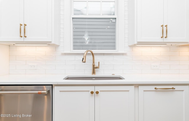 kitchen featuring sink, stainless steel dishwasher, white cabinets, and backsplash