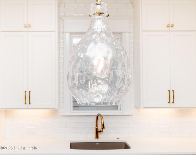 details with white cabinetry, sink, and tasteful backsplash