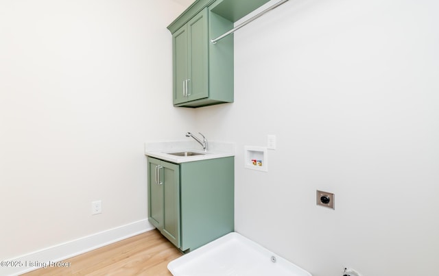 laundry room featuring sink, cabinets, light hardwood / wood-style floors, hookup for a washing machine, and hookup for an electric dryer