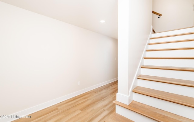 stairway with hardwood / wood-style flooring