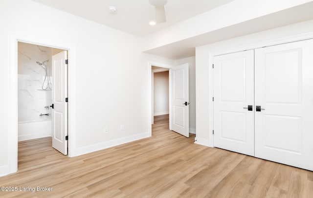 unfurnished bedroom with light wood-type flooring, connected bathroom, ceiling fan, and a closet