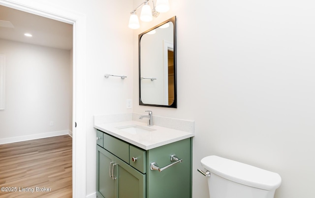 bathroom featuring vanity, hardwood / wood-style floors, and toilet