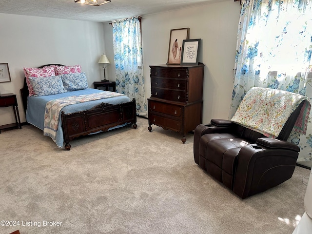 bedroom featuring a textured ceiling and light colored carpet