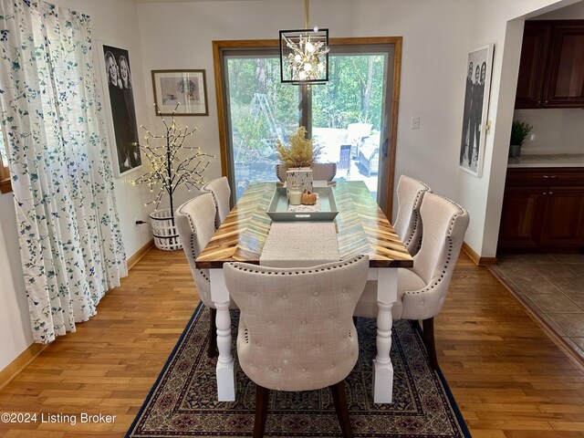 dining area with light wood-type flooring and a chandelier