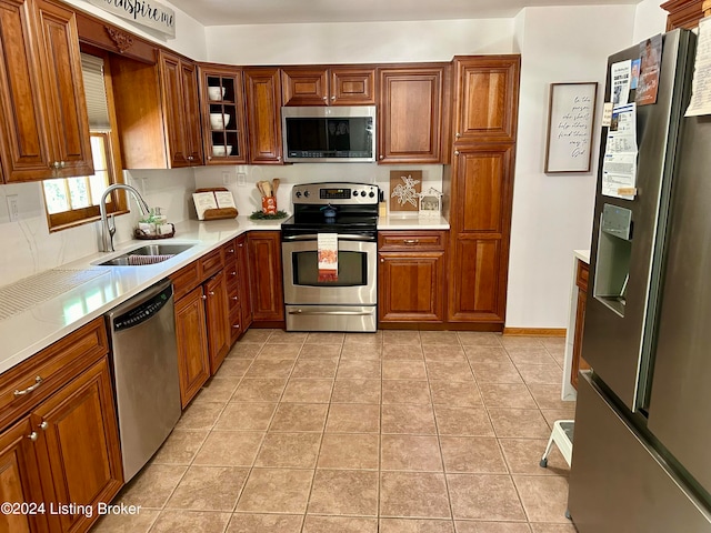 kitchen featuring light tile patterned flooring, sink, and stainless steel appliances