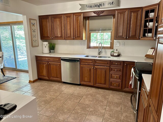 kitchen featuring stainless steel appliances, light tile patterned floors, and sink