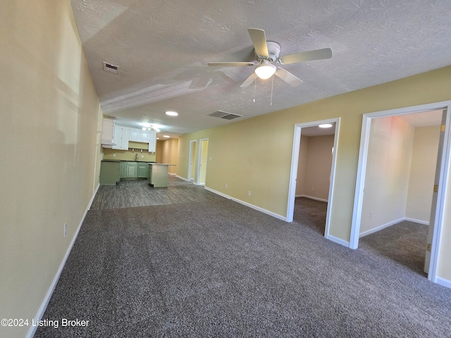 unfurnished living room with carpet flooring and a textured ceiling