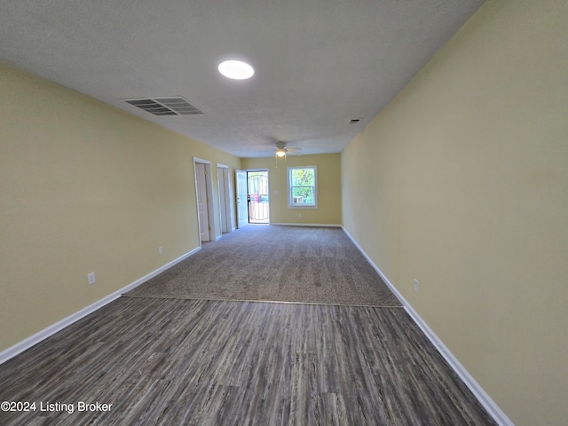 spare room featuring ceiling fan, dark hardwood / wood-style flooring, and a textured ceiling