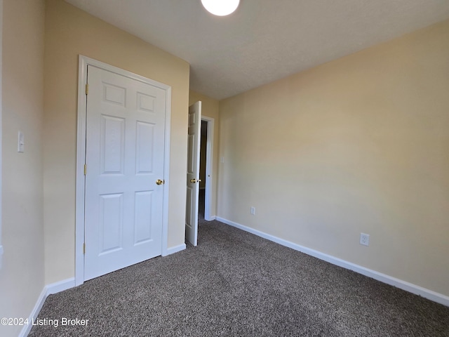 unfurnished bedroom featuring dark colored carpet