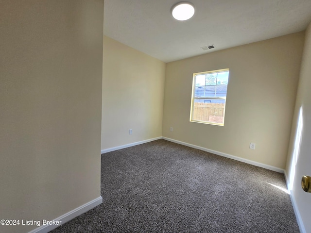 empty room featuring dark colored carpet