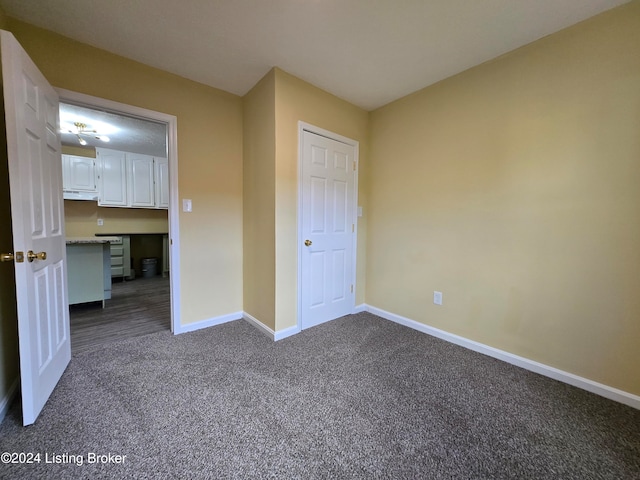 unfurnished bedroom featuring dark colored carpet