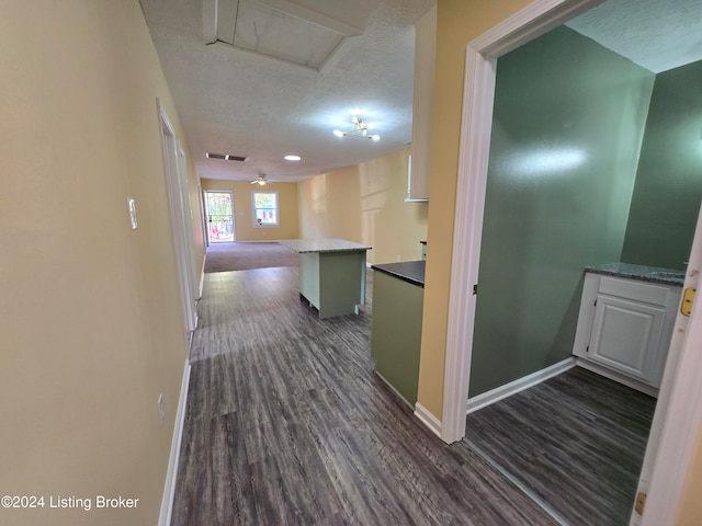 hall featuring dark hardwood / wood-style flooring and a textured ceiling