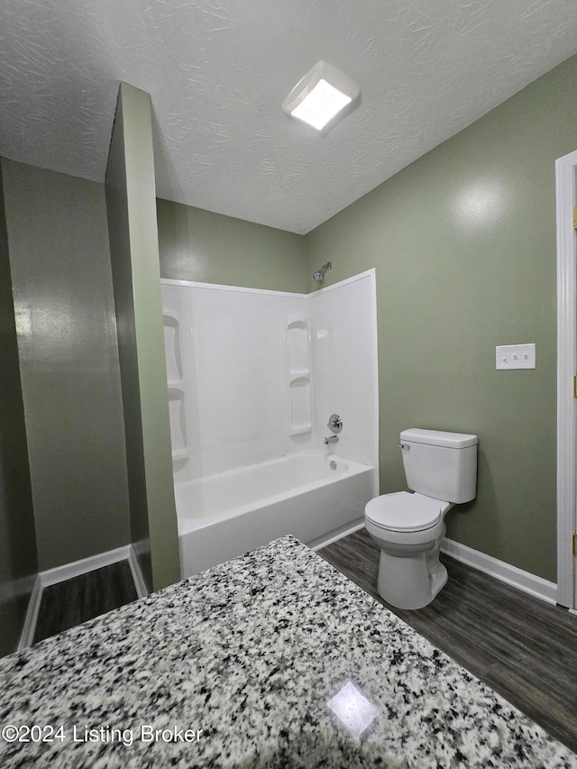 bathroom featuring toilet, shower / bath combination, a textured ceiling, and hardwood / wood-style flooring