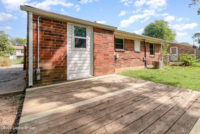 wooden terrace featuring central air condition unit and a yard