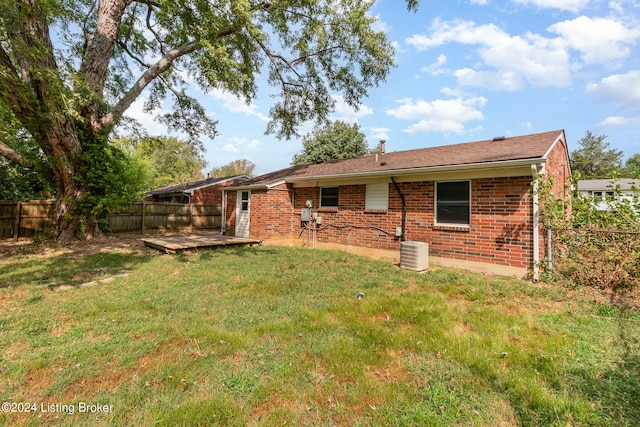 rear view of house with a yard and central AC unit