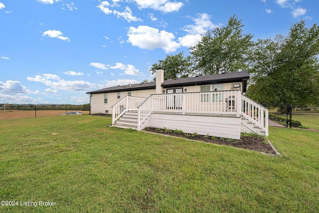 rear view of house featuring a yard and a deck