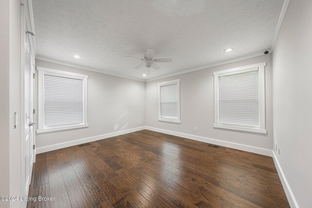 empty room featuring ceiling fan, a textured ceiling, crown molding, and dark wood-type flooring