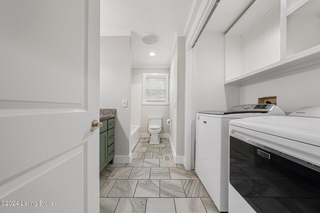 laundry room with ornamental molding and washer and clothes dryer