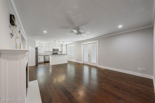 unfurnished living room featuring a textured ceiling, crown molding, dark hardwood / wood-style flooring, and ceiling fan