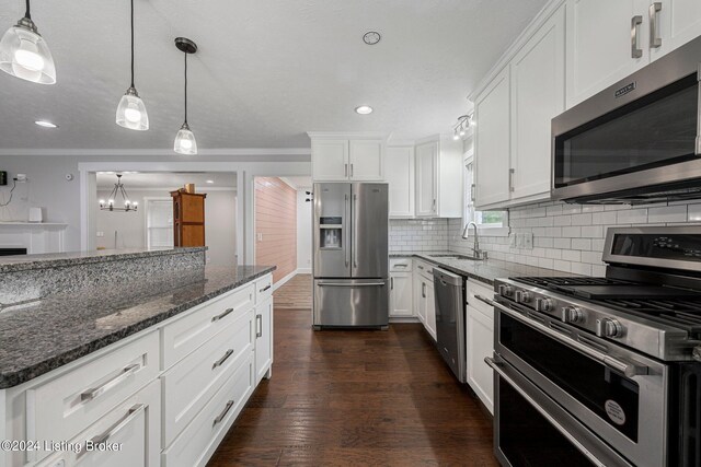 kitchen featuring white cabinets, stainless steel appliances, decorative light fixtures, dark hardwood / wood-style floors, and sink