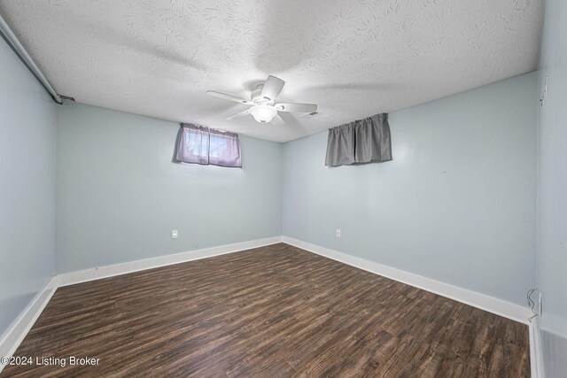 spare room with ceiling fan, a textured ceiling, and dark hardwood / wood-style flooring