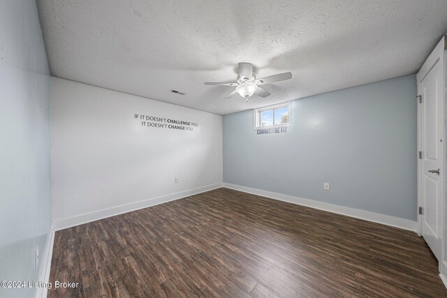 empty room featuring ceiling fan, a textured ceiling, and dark hardwood / wood-style flooring