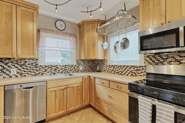 kitchen featuring appliances with stainless steel finishes, backsplash, sink, and a wealth of natural light