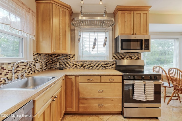 kitchen with light tile patterned flooring, appliances with stainless steel finishes, sink, and decorative backsplash