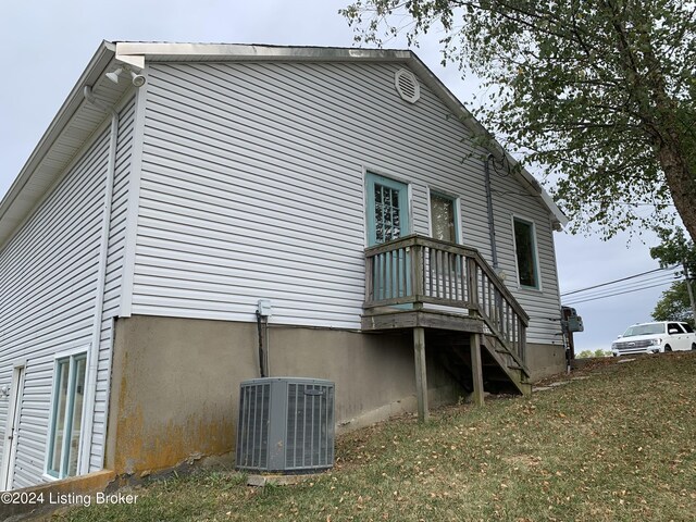 back of property with a lawn and central air condition unit