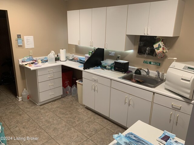 kitchen featuring sink and white cabinetry